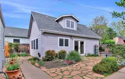 a white house with a fence and a yard at Oasis East Sac Charming Home with Saltwater Pool and Casita in Sacramento