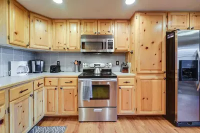 a kitchen with wooden cabinets and stainless steel appliances at 4 Mi to Downhill Ski Resort! Spacious Family Haven in Truckee