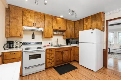 a kitchen with wooden cabinets and a white refrigerator at Views, Hot Tub, Outdoor Shower, 15m from Sequoia in Three Rivers