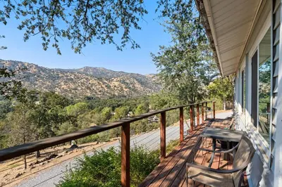 a porch with a bench and a view of the mountains at Views, Hot Tub, Outdoor Shower, 15m from Sequoia in Three Rivers