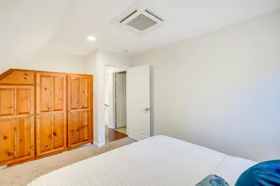 a bedroom with two beds and a wooden cabinet at Pollock Pines Cabin Game Room with AandC and Heat! in Pollock Pines