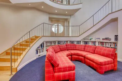 a red couch in a room with a staircase at Remarkable Roundhouse Retreat in Truckee