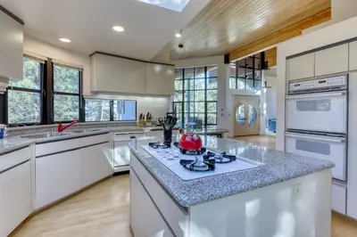 a large kitchen with white cabinets and a counter top at Remarkable Roundhouse Retreat in Truckee