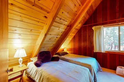 a bedroom with two beds in a room with wooden walls at Tranquil Treehouse Haven in Tahoe City
