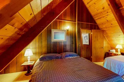 a bedroom with a bed in a wooden attic at Tranquil Treehouse Haven in Tahoe City