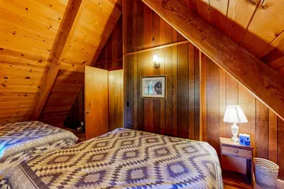 a bedroom with two beds in a wooden cabin at Tranquil Treehouse Haven in Tahoe City