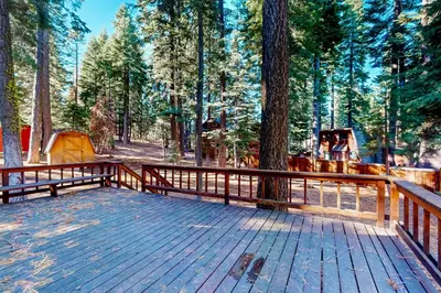 a wooden deck with a wooden fence in a forest at Tranquil Treehouse Haven in Tahoe City