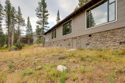 a house on a hill next to a field at Mountain Condo with Fireplace in Kirkwood Ski Resort in Kirkwood