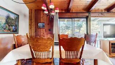 a dining room with a table with chairs and a chandelier at Villa de los Pinos #40 condo in Mammoth Lakes