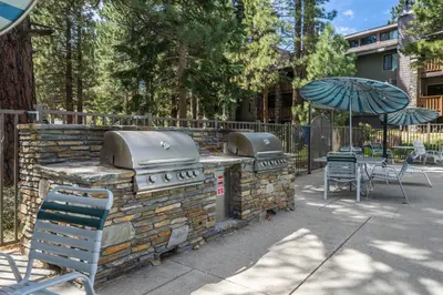 a patio with an outdoor grill and an umbrella at New Listing 2 bedroom +Loft 2 bath Summit E Bldg. #8 condo sleeps 8, Steps to Eagle Lodge/Chair #15 in Mammoth Lakes