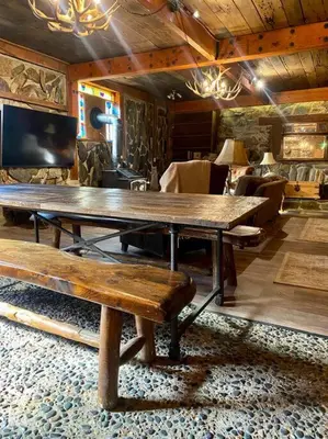 a dining room with a large wooden table and benches at Vintage 1857~Stone & Beam Cellar in Amador City
