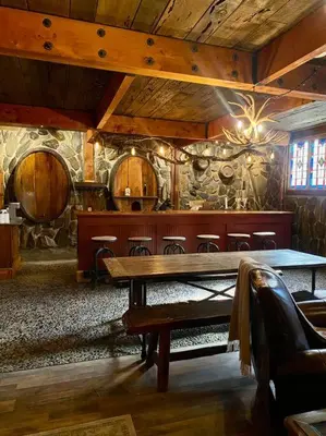 a room with a wooden table and a stone wall at Vintage 1857~Stone & Beam Cellar in Amador City