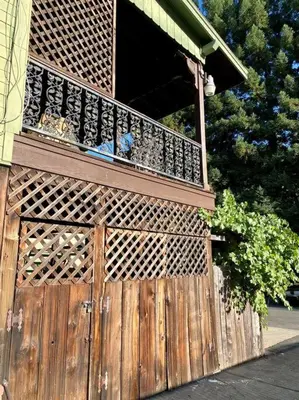 a wooden gate with a balcony on a house at Vintage 1857~Stone & Beam Cellar in Amador City