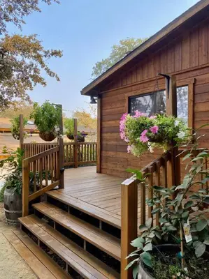 a wooden deck with potted plants and a house at B-B Ranch Cottage~Heart of Gold Country~*HOT TUB* in Pilot Hill