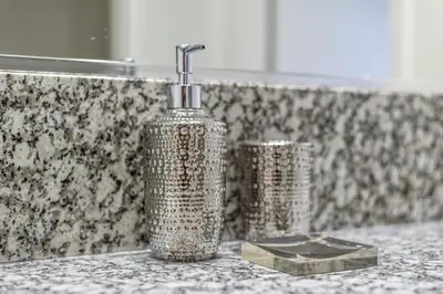 a silver bottle on a counter in a bathroom at 3BR Cozy Home~ Stylish & New ~ UC Merced ~ en route Yosemite! in Merced