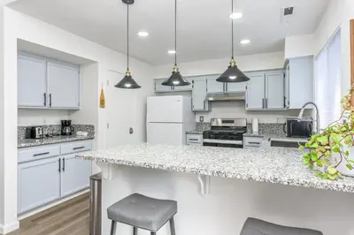 a kitchen with white cabinets and a counter top at 3BR Cozy Home~ Stylish & New ~ UC Merced ~ en route Yosemite! in Merced