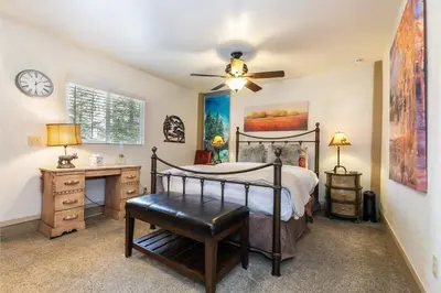 a bedroom with a bed and a desk and a fan at Classic 3BD Tahoe Cabin with Hot Tub in Carnelian Bay