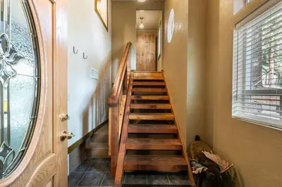 a wooden staircase in a room with a window at Classic 3BD Tahoe Cabin with Hot Tub in Carnelian Bay