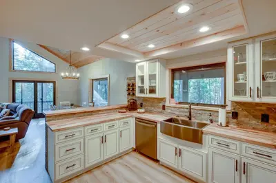 a large kitchen with white cabinets and a sink at Arnold Cabin Near Calaveras Big Trees State Park! in Arnold