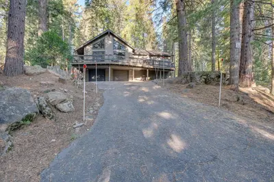 a large house in the middle of a forest at Arnold Cabin Near Calaveras Big Trees State Park! in Arnold