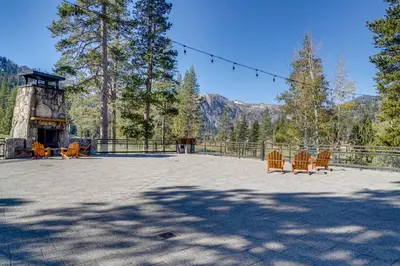 a patio with chairs and a fireplace and trees at Breathtaking Olympic Valley Gem Walk to Chairlift in Olympic Valley