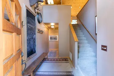 a hallway with a staircase and a stair case at Alpen Glow by Tahoe Getaways - Private Hot Tub, Close to Northstar in Carnelian Bay