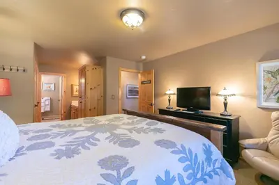 a bedroom with a bed and a flat screen tv at Alpen Glow by Tahoe Getaways - Private Hot Tub, Close to Northstar in Carnelian Bay