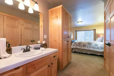 a bathroom with a sink and a bedroom with a bed at Alpen Glow by Tahoe Getaways - Private Hot Tub, Close to Northstar in Carnelian Bay