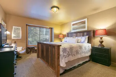 a bedroom with a bed and a desk and a window at Alpen Glow by Tahoe Getaways - Private Hot Tub, Close to Northstar in Carnelian Bay