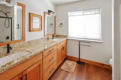 a bathroom with two sinks and a large window at Agate Bay Gem by Tahoe Getaways - Charming Getaway with Cozy Fireplace Near Hiking and Biking Trails in Tahoe Vista