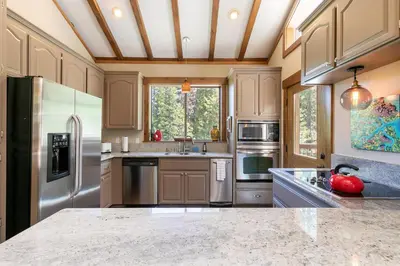 a kitchen with stainless steel appliances and a ceiling at Alpine Escape by Tahoe Getaways - Shuttle to Ski Slopes & Fireplace in Alpine Meadows