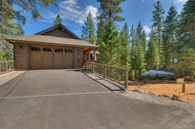 a house with a garage and a fence at Bluebird Lodge by Tahoe Getaways - 4 BR with Hot Tub, Pool Table & Lake Views in Carnelian Bay