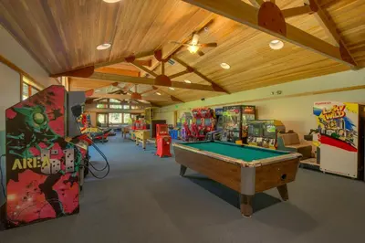 a room with a pool table and arcade games at Bitter Brush by Tahoe Getaways -4 BR Pet Friendly, Northstar Home with Hot Tub, Pool Table, & Ski Shuttle in Truckee