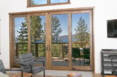 a living room with a sliding glass door with a view at Beaver Lake View by Tahoe Getaways - Pet Friendly 3 BR with Hot Tub, Wood Fireplace & Close to Skiing in Kings Beach