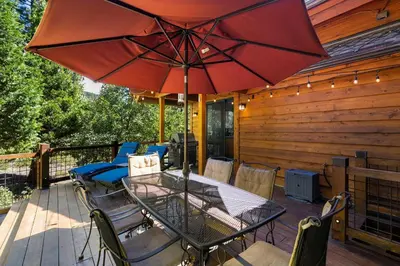a patio with a table and a red umbrella at Mountain Zen Tahoe Luxury Property Incline Village Lakeview in Incline Village