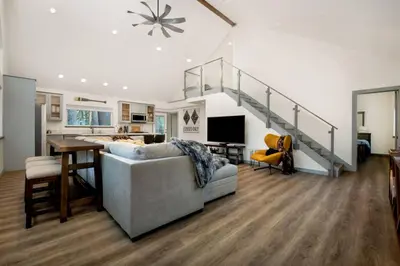 a living room with a couch and a staircase at Newly Built Luxury Villa in the Sierra Mountains in Alta