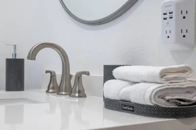 a bathroom counter with a stack of towels next to a sink at Newly Built Luxury Villa in the Sierra Mountains in Alta
