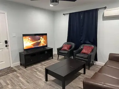 a living room with two chairs and a flat screen tv at Guest house near UCD Med. Center in Sacramento