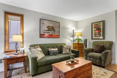 a living room with a green couch and a chair at Alpine Alcove: Tahoe Tranquility Near Kings Beach in Tahoe Vista