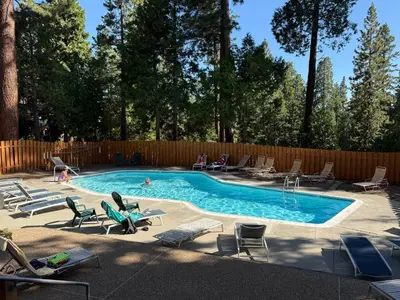 a swimming pool with chairs and people in it at Alpine Alcove: Tahoe Tranquility Near Kings Beach in Tahoe Vista