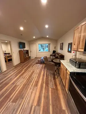 a kitchen and living room with wooden floors at Wonky Donkey Den 30 mi to Yosemite Arch Entrance in Mariposa