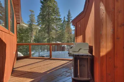 a grill on a wooden deck on a house at Big John at Alpine Meadows by Tahoe Getaways - Mountain Views, Cozy Fireplace, Shuttle to Slopes! in Alpine Meadows
