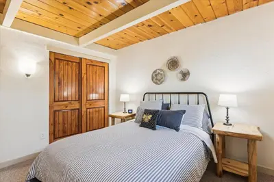 a bedroom with a bed with blue pillows at Cedar Chalet by Tahoe Getaways - Stunning 3BR with Fireplace & Pet Friendly in Tahoe Vista
