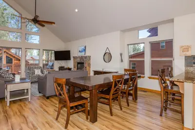 a dining room and living room with a table and chairs at Cedar Crest at Winter Creek by Tahoe Getaways - 3BR, Walk to Ice Skating, Near Downtown and Northstar with Private Hot Tub! in Truckee