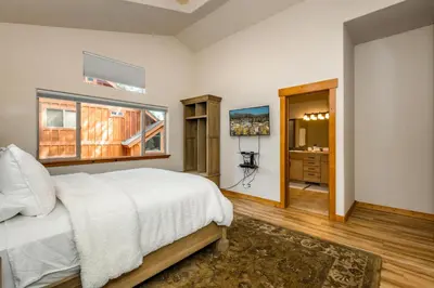 a bedroom with a white bed and a window at Cedar Crest at Winter Creek by Tahoe Getaways - 3BR, Walk to Ice Skating, Near Downtown and Northstar with Private Hot Tub! in Truckee
