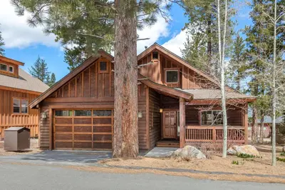 a log home with a tree at Cedar Crest at Winter Creek by Tahoe Getaways - 3BR, Walk to Ice Skating, Near Downtown and Northstar with Private Hot Tub! in Truckee