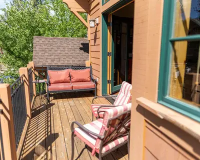 a patio with two chairs and a couch on a porch at Coyote Run Retreat by Tahoe Getaways - 3BR Pet Friendly with HOA Amenities, Minutes to Downtown Truckee & Northstar Resort! in Truckee