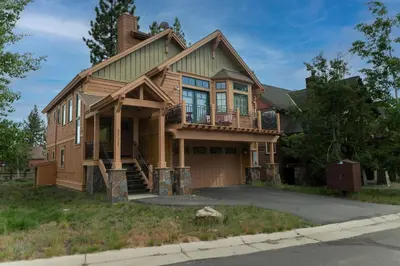a wooden house with a balcony on a street at Coyote Run Retreat by Tahoe Getaways - 3BR Pet Friendly with HOA Amenities, Minutes to Downtown Truckee & Northstar Resort! in Truckee