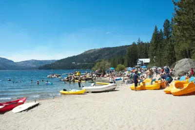 a crowd of people on a beach with boats at Cottonwood by Tahoe Getaways - 3BR Tahoe Donner with 2 Bonus Rooms, Hot Tub, Fireplace, Ping Pong & HOA Amenities in Truckee