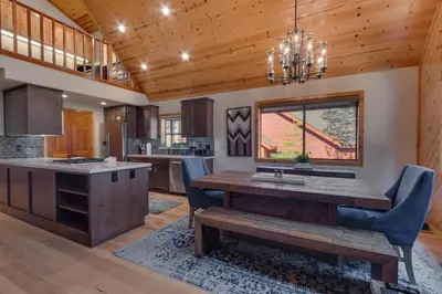 a kitchen with a wooden table and a dining room at Cottonwood by Tahoe Getaways - 3BR Tahoe Donner with 2 Bonus Rooms, Hot Tub, Fireplace, Ping Pong & HOA Amenities in Truckee